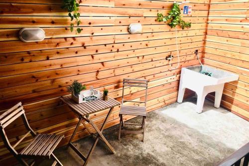 a room with a wooden wall with a sink and chairs at Apartamento Vista do Mar A in Ribeira Quente