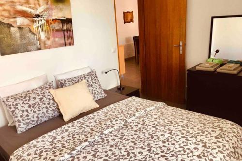 een slaapkamer met een groot bed met kussens erop bij Apartamento Vista do Mar A in Ribeira Quente