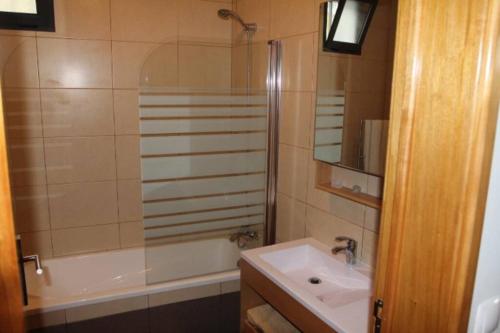 een badkamer met een bad, een wastafel en een douche bij Apartamento Vista do Mar A in Ribeira Quente