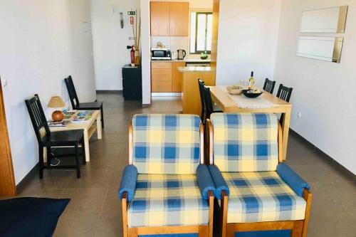 a living room with two chairs and a table at Apartamento Vista do Mar B in Ribeira Quente