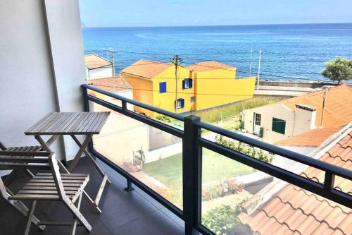 a balcony with a table and a view of the ocean at Apartamento Vista do Mar B in Ribeira Quente