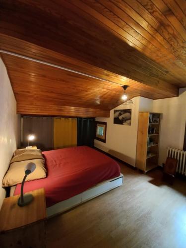 une chambre avec un grand lit avec un plafond en bois dans l'établissement Logement mansardé dans maison avec jardin en bord de piste, vue montagne, aux Houches