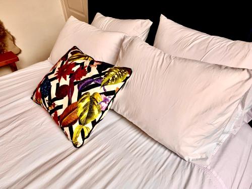 a bed with white sheets and a pillow on it at DEVON BEACH STATION in Paignton
