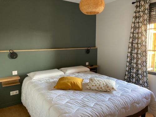 une chambre avec un lit avec deux oreillers dessus dans l'établissement Au coeur du Bassin d'Arcachon,très bel appartement avec terrasse, à Audenge