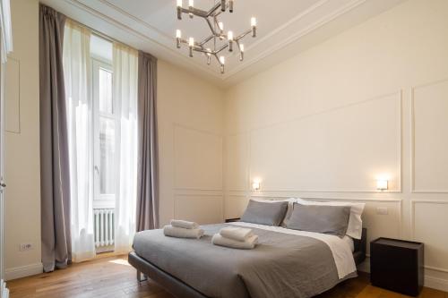 a bedroom with a bed and a chandelier at Florence Luxury Apartment al Duomo in Florence