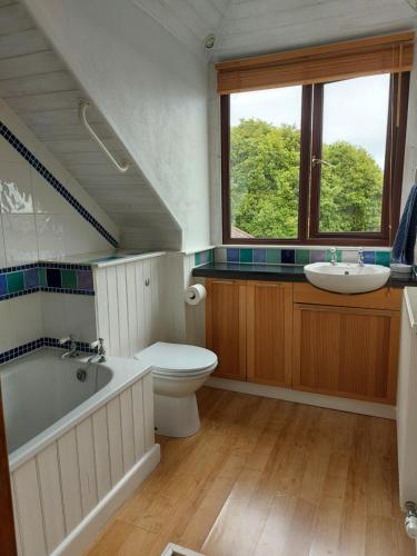 uma casa de banho com uma banheira, um WC e um lavatório. em Fairholme Apartment em Dartmouth