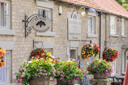 a building with flowers in front of it at The Royal Oak in Gillamoor