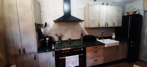 a kitchen with wooden cabinets and a black stove top oven at La Cantina in Chanos