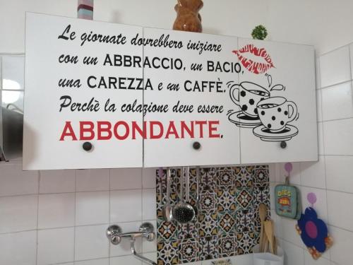 a sign above a sink in a kitchen at Le Volte di Lo Re in Surbo