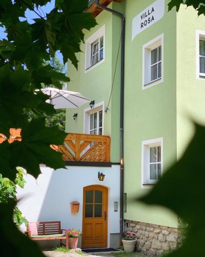 a green and white building with a wooden door at Villa Rosa in Bad Gastein