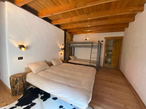 sypialnia z łóżkiem w pokoju z drewnianym sufitem w obiekcie Giasson w mieście Valgrisenche