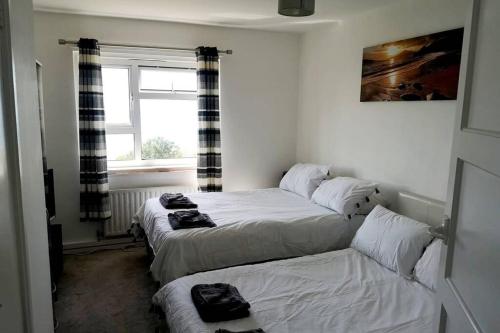 sypialnia z 2 łóżkami i oknem w obiekcie Jurassic View 3 Bed House with Hot Tub w mieście Castletown