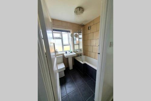 a bathroom with a tub and a sink and a mirror at Chesil View in Castletown