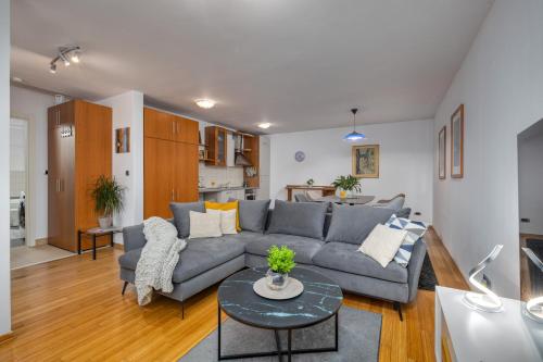 a living room with a couch and a table at TERRA MAGICA DELUXE Apartment Or Room with Private Parking, Terrace and Sea View in Rijeka
