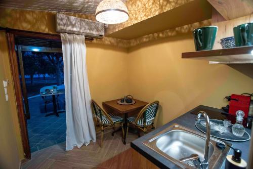 a kitchen with a sink and a table with chairs at KRISSAIA SEASIDE SUITES in Galaxidhion