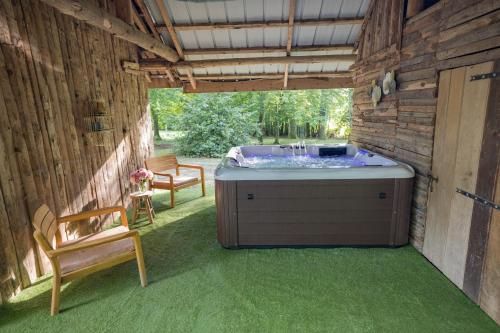 a hot tub sitting inside of a building with a chair at Chateau des Ayes - Chambres & suites in Saint-Étienne-de-Saint-Geoirs