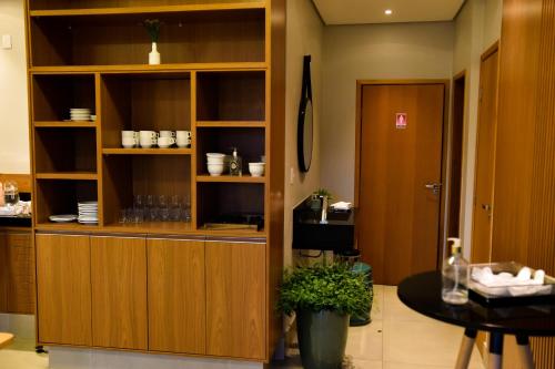 una cucina con armadi in legno e un tavolo in una stanza di Água Branca Park Hotel ad Araçatuba