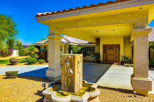 a house with a fountain in front of it at Cool Pool Retreat in Bermuda Dunes