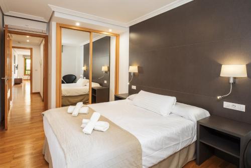 um quarto de hotel com uma cama e um espelho em Lanzahost LUX XXI em Arrecife