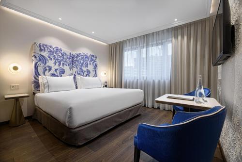 a hotel room with a bed and a table and chairs at Eurostars Universal Lisboa in Lisbon