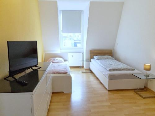 Cette chambre comprend 2 lits et une télévision à écran plat. dans l'établissement LEA Apartments Luxus-3-Raum-Wohnung mit Tiefgarage, à Leipzig