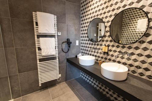 a bathroom with two sinks and a mirror at Petit-Roannay in Stavelot