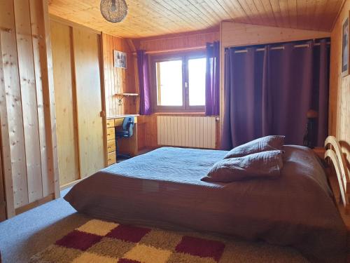 une chambre avec un lit dans une pièce avec une fenêtre dans l'établissement Le Si-près Pied des pistes, aux Carroz d'Arâches