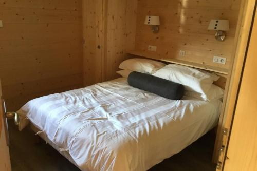 a bedroom with a bed with white sheets and pillows at Modern Comfortable Chalet with large terrace in Morzine