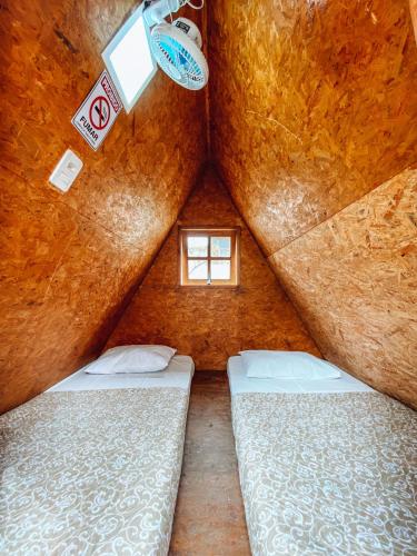 two beds in a room with a small window at Camping Marymar in Paraty