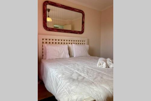 - une chambre avec un lit blanc et un miroir dans l'établissement Aroeira - Sea & Golf Apartment, à Aroeira