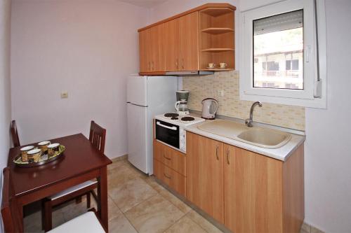 a small kitchen with a sink and a white refrigerator at Coralli Studios in Ormos Panagias