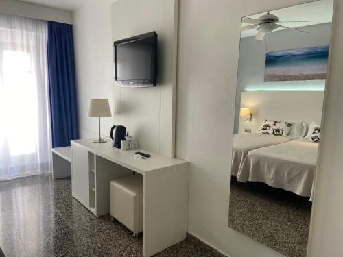 a hotel room with a television and a sink at Hostal Pitiusa in Ibiza Town