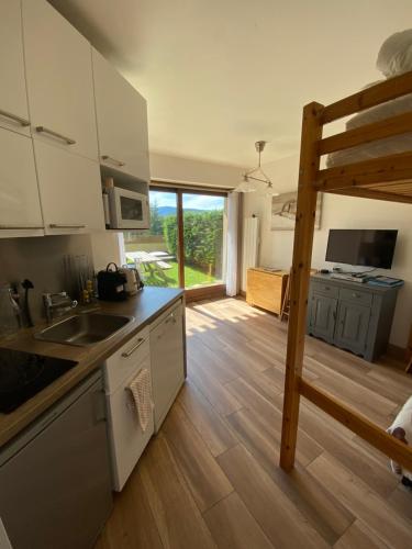 une cuisine avec des armoires blanches et un plancher en bois dans l'établissement Appartement 2 pièces avec Sauna et Hamam dans la résidence le Diamant, à Villard-de-Lans