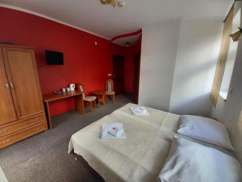ein Hotelzimmer mit einem Bett, einem Schreibtisch und einem Stuhl in der Unterkunft Willa Romantika in Kudowa-Zdrój