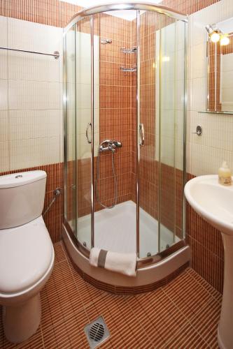 a bathroom with a shower and a toilet and a sink at Coralli Studios in Ormos Panagias