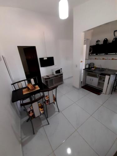 Sala de estar blanca con mesa y TV en Ap 09-A 50 Metros da Praia Flats Completamente Mobiliados, en Paulista