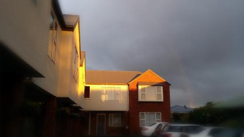 a house with a light on the side of it at Rosewood Court Motel in Christchurch