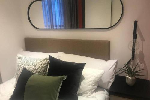 a mirror above a white bed with pillows and a mirror over it at Luxurious Studio in the heart of Cape Town CBD in Cape Town