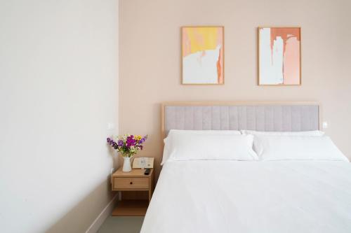 a bedroom with a white bed and two pictures on the wall at Numa Madrid Script in Madrid