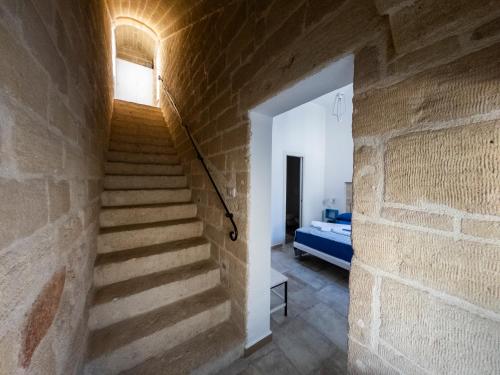 a staircase in a room with a brick wall at Pietracielo B&B in Polignano a Mare