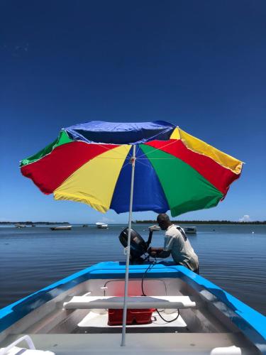 a man sitting on a boat under an umbrella at Summerdays Studios in Coteau Raffin