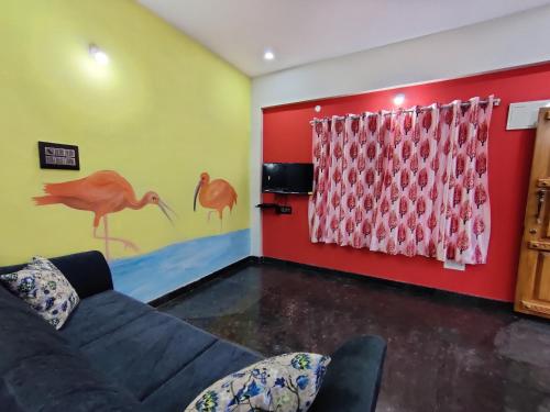 a living room with a couch and a red wall at Royal Wings Apartments in Mysore
