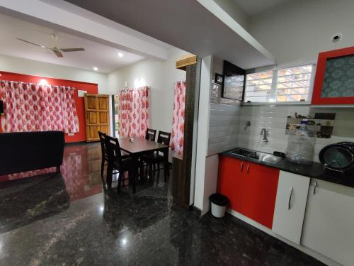 a kitchen and dining room with a table and chairs at Royal Wings Apartments in Mysore