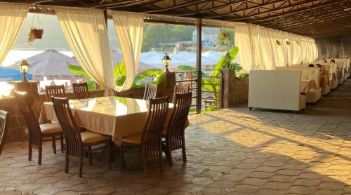 - un restaurant avec une table et des chaises et une vue sur l'océan dans l'établissement Velvet Sea, à Dzhubga