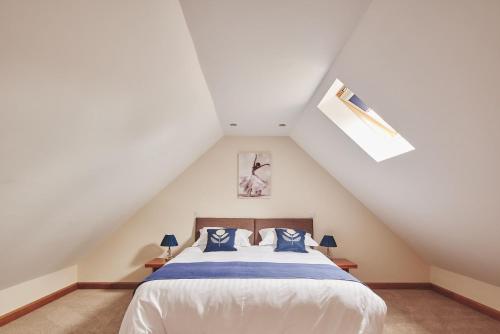 a bedroom with a white bed with blue pillows at Cleeton Cottage in Elmbridge