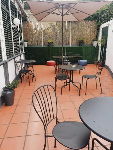 a patio with tables and chairs and an umbrella at Hospedaria Pôr do Sol in Funchal