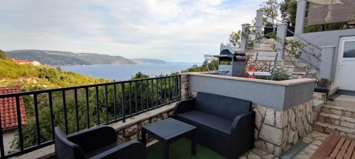 a balcony with chairs and a view of the water at Apartments Plavčić in Plomin