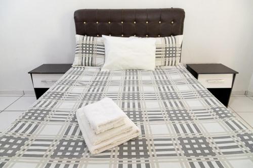 a bedroom with a bed with a black and white bedspread at Búzios Internacional Apart Hotel in Búzios