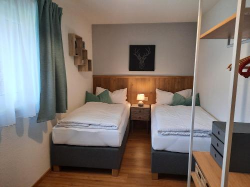 two beds in a small room with a mirror at Haus Adrian in Wald am Arlberg