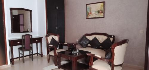 ein Wohnzimmer mit einem Sofa, Stühlen und einem Tisch in der Unterkunft hotel cote d'or m'diq in Mʼdik